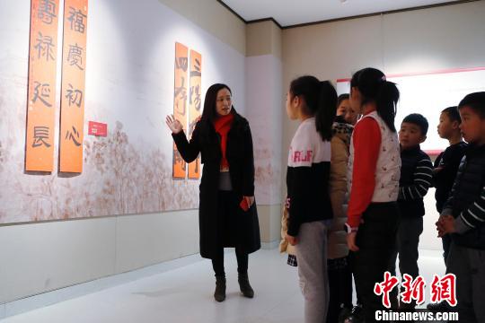 上海市文联工作人员为孩子们讲解春联。 殷立勤 摄
